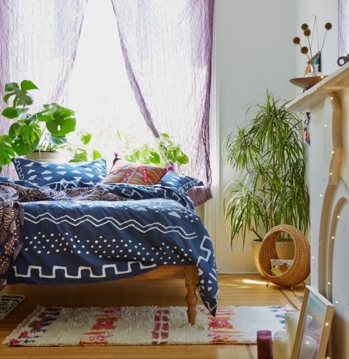 hipių prašmatnaus stiliaus interjero dizainas su medine lova, padengta dekoratyvinėmis pagalvėmis ir anties mėlynos spalvos užvalkalu su baltais raštais