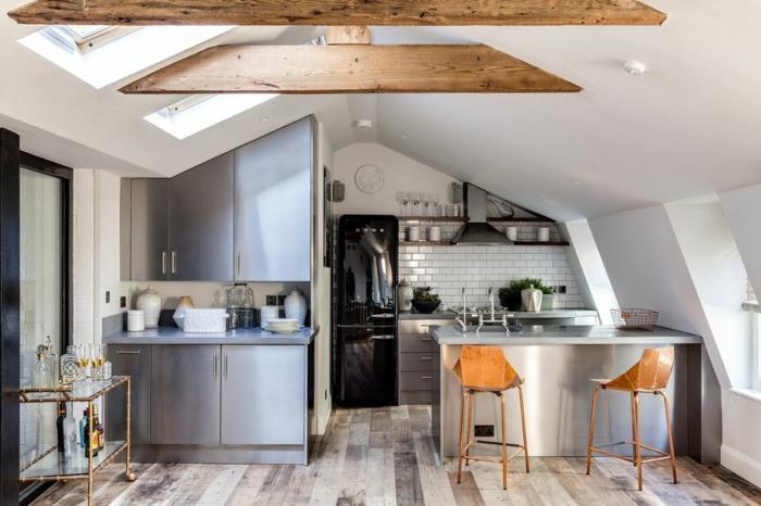 virtuvė su laminuotomis grindimis, medinėmis sijomis, pilkomis spintelėmis, serviravimo vežimėliu, juodu šaldytuvu, moderniomis kėdėmis