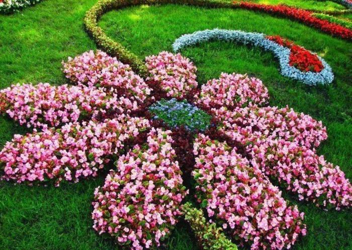 yeşil bir çim üzerinde kırmızı, pembe, mavi ve yeşil büyük bir çiçek şeklinde çiçeklik, orijinal bahçe dahi fikri