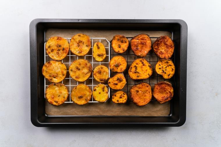 Patates cipsi, teglia con patate al forno, teglia con carta da forno e reti di metallo