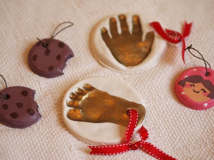 ayak ve el baskılarıyla boyanmış tuzlu hamurdan küçük orijinal nesneler ve ağaca asmak için kurdeleli sahte kurabiyeler