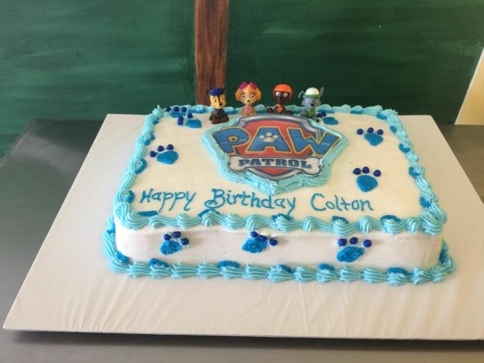 bela paw patrol torta z modro dekoracijo, logotip paw patrol, figurice paw patrol