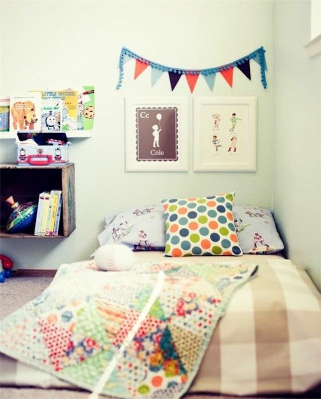 balta siena, įvairiaspalvės pagalvėlės ir lovos užvalkalas, sienų apdaila, piešiniai, knygų lentyna, pagrindinė spintelė, „Montessori“ miegamojo pavyzdys