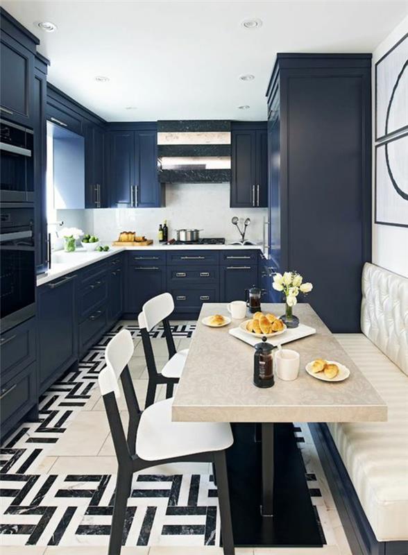 kaip modernizuoti ąžuolinę virtuvę, perdažyti virtuvės spintelę anties mėlynos, juodos ir baltos plytelių grindimis su grafiniais raštais, stačiakampį stalą smėlio spalvos, sofą dramblio kaulo spalvos, dvi kėdes baltos ir juodos spalvos