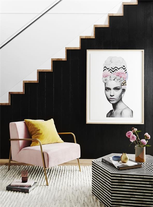 svetainė su juoda siena su baltais ir mediniais laiptais, rožinės spalvos pudra su aukso spalvos foteliu ir rožių puokšte