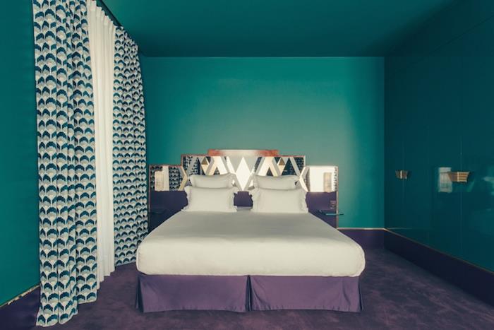 petrolej modra barva za prebarvanje sten spalnice, belo in vijolično posteljno perilo in vijolična preproga, bela, siva in zelena zavesa z geometrijskimi vzorci