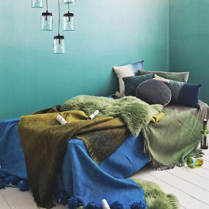 barva spalnice za odrasle, pobarvana bela in zelena stena, senčen učinek, posteljnina v zeleni in modri barvi, svetilka za kozarec in svetel parket za vzdušje ob morju