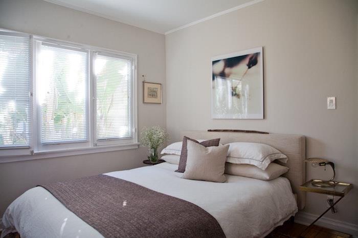 svetlo sive stene, belo posteljnina, perilo in temno rjava, umetniška dekoracija sten s fotografijami, oblikovalska nočna omarica, bela okna