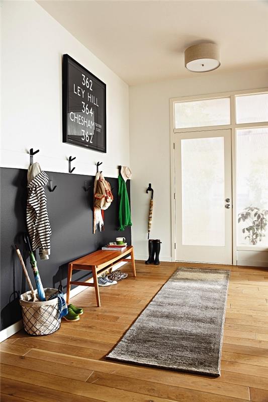 minimalistična postavitev vhoda z dnom stene pobarvano črno, da omeji prostor garderobe