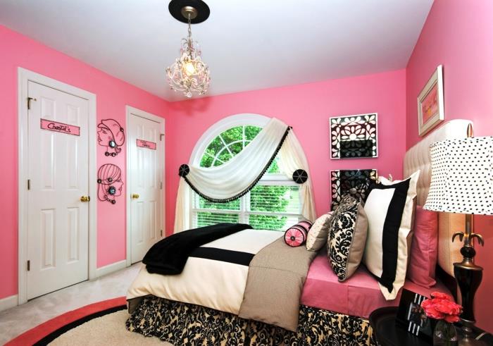 dekor spalnice najstnice, barva spalnice dekleta, roza stene, dve beli vrati, baročni lestenec s črnim frizom, visoka posteljna žimnica, stoječa luč z belim senčnikom