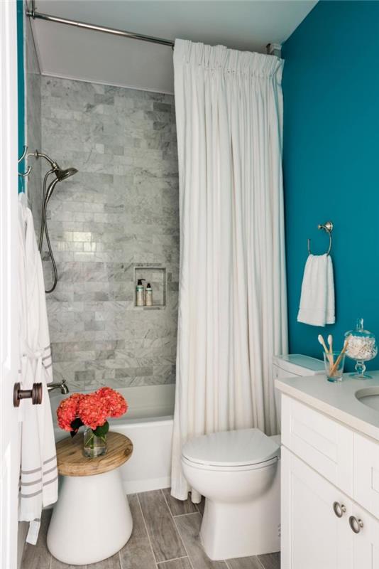 majhen kopalniški dekor s kadjo in zavesami, katere barve za kopalnico v beli in mornarsko modri barvi