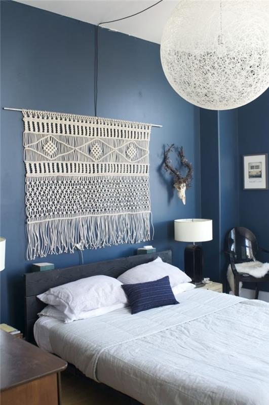 mavi duvar boyama yatak odası dekoru makrome başlık ipi beyaz ve siyah başucu lambası siyah sandalye dekoratif boynuzlar
