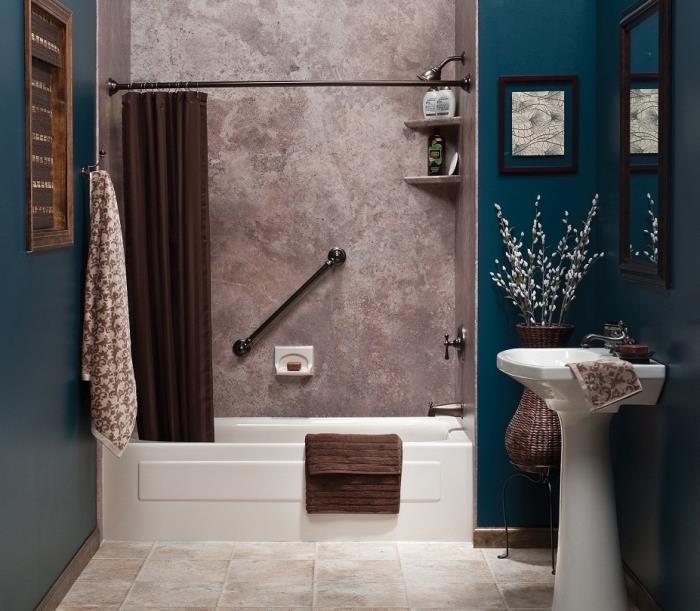 kopalnica s tušem in kadjo, opremljena z vogalnimi policami za shranjevanje, soba s temno modrimi stenami s sivim odsekom stene