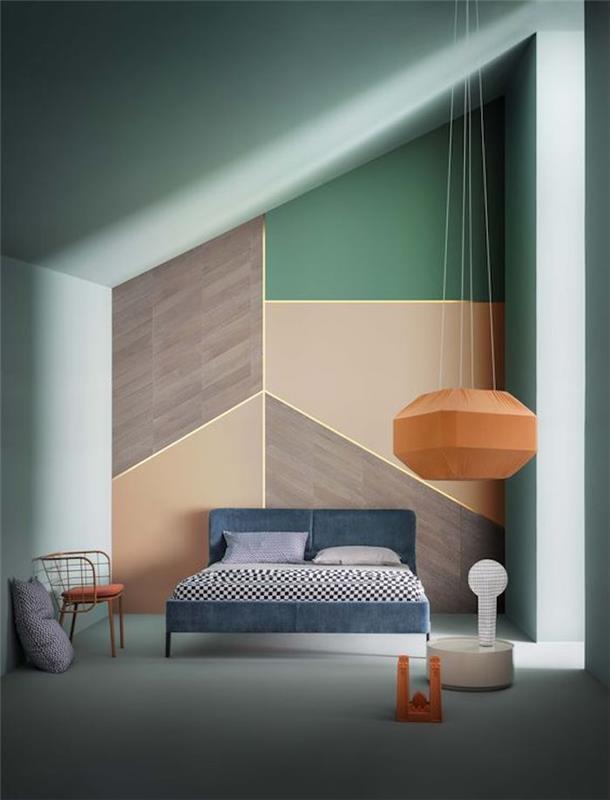 vodno zelena deko stenska barva, senčnik celadon in naglasna stena z geometrijskimi figurami v oranžni, rjavi in ​​zeleni barvi, mornarsko modra postelja, stol in originalno oranžno vzmetenje