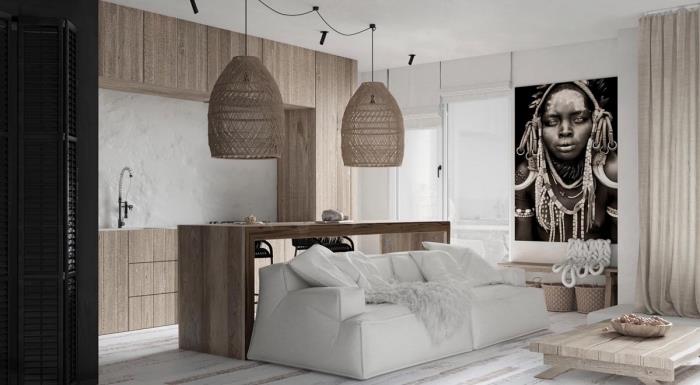 Afrikos stiliaus dekoras studijoje su baltomis sienomis su baltomis medinėmis grindimis ir šviesiais mediniais baldais, baltos sofos modelis, padengtas dirbtinio kailio pledu