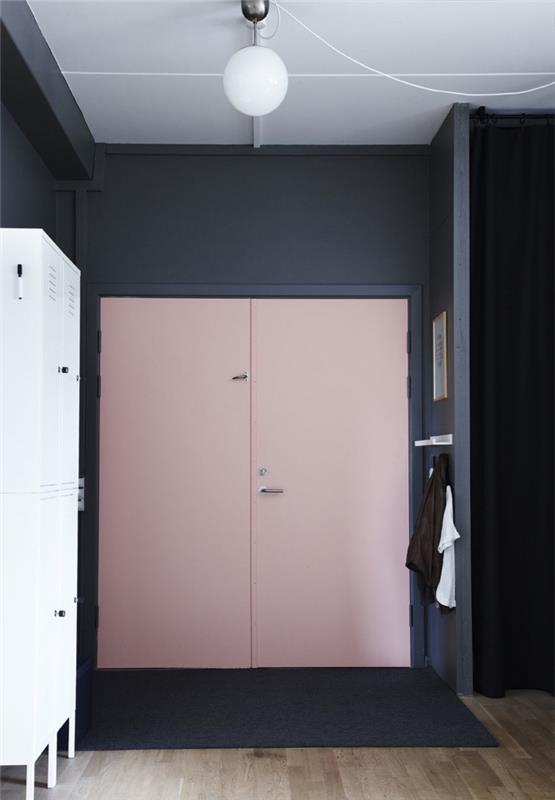 įėjimo durys, perdažytos rožine spalva, sukuriančios šiuolaikišką ir prašmatnią atmosferą įėjime, nes siejamos su vidurnakčio mėlynomis sienomis