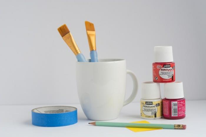 gençler için manuel aktivite, beyaz kahve kupasını boya ile süslemek için malzemeler, kırmızı boya ile kişiselleştirilmiş kendin yap kupa