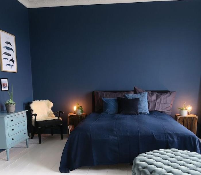 beli strop in tla ter polnočno modre stene, modre in rjave blazine in blazine, lesena nočna omarica, dekoracija spalnice za odrasle