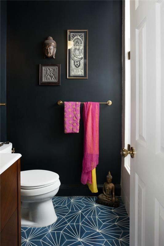 mažos erdvės tualetas, mėlynos grindys, Budos statulėlė, rožinis rankšluostis, baltai dažytos durys