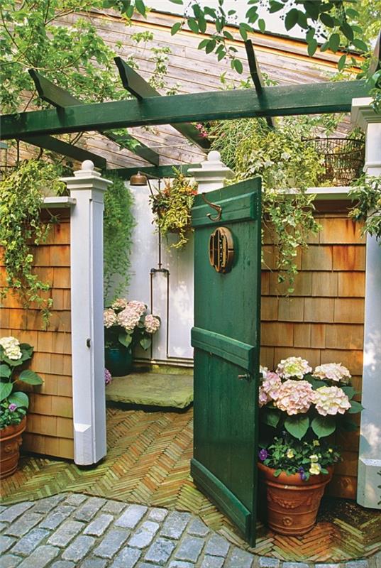 kako urediti kopalnico na dvorišču, primer kopalnice na vrtu z belimi stenami in bakreno prho