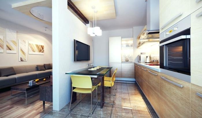 mutfak, uzun siyah bir masa, sarı sandalyeler, bölme duvarı ve modern bir oturma odası olan küçük bir stüdyo nasıl kurulur