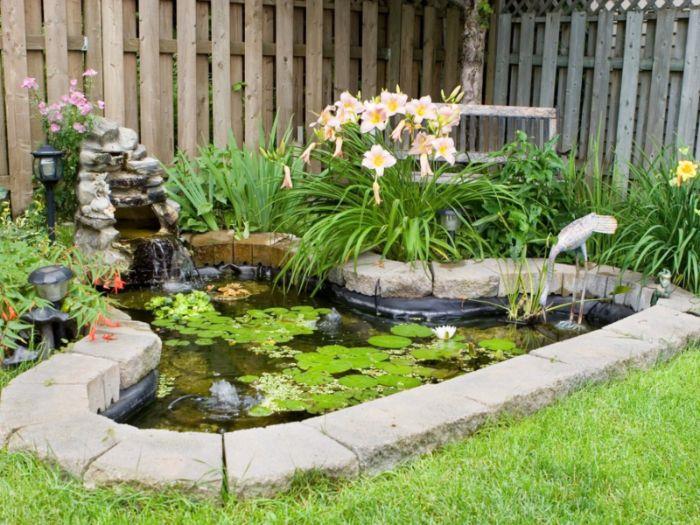 majhen naravni vrtni ribnik Zen vrtni slog, obdan z vegetacijo in z leseno ograjo nimfej zelena trava
