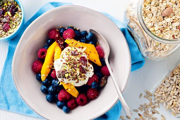 idealūs pusryčiai norintiems numesti svorio ir subalansuotai maitintis, paprastas dubuo raudonųjų vaisių, jogurto ir sėklų bei riešutų mišinio