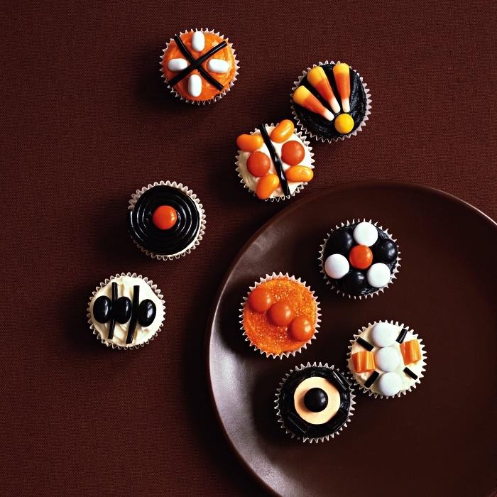 Helovino keksiukai su oranžine, nespalvota glazūra, papuošti konditerijos gaminiais, idėja mažam Helovino pyragui