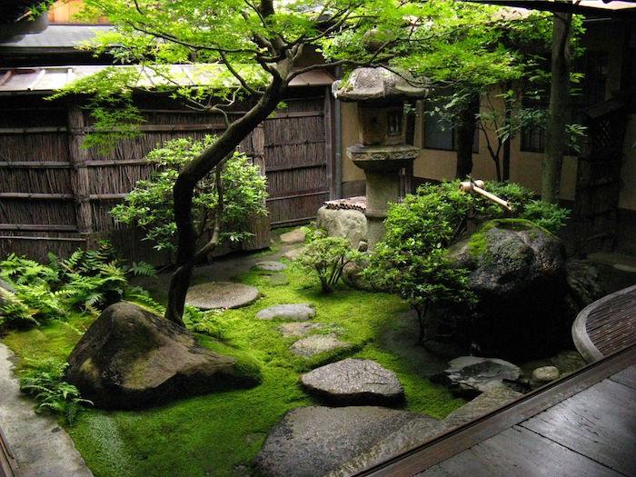 majhen zeleni japonski vrt Tsukiyama z drevesnimi rastlinami in spomladansko ter kamnito potjo Tobi-ishi