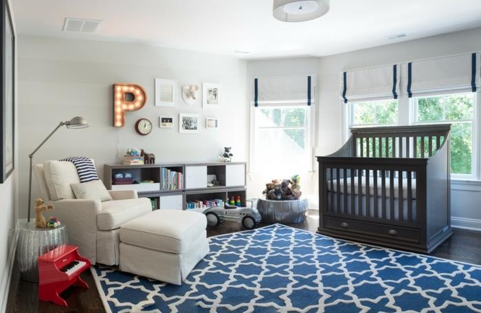 mėlynas kilimas, baltas fotelis, mažas raudonas fortepijonas, berniuko vaiko kambario dekoras, tamsiai medinė kūdikio lova