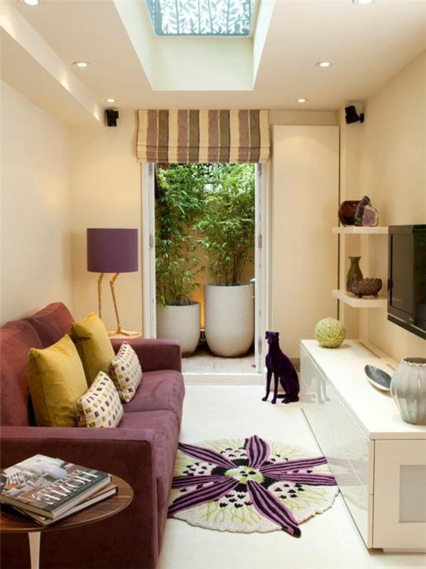 majhna dnevna soba-vijolična-kavč-okrogla preproga-vijolična-kavč-okrasne-blazine-vijolična-svetilka