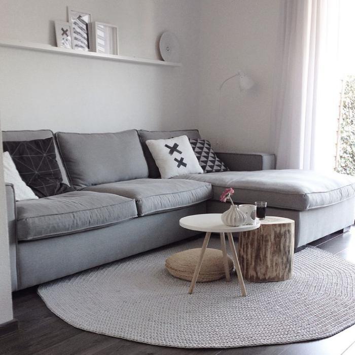 mažas apvalus kilimas-pilka sofa ir mažas kavos staliukas