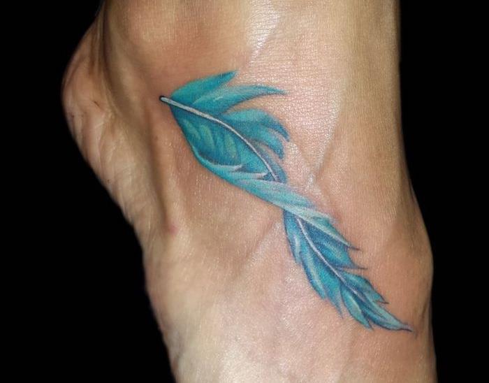 tattoo woman, risanje na koži z modrim perjem, tattoo ideja za žensko