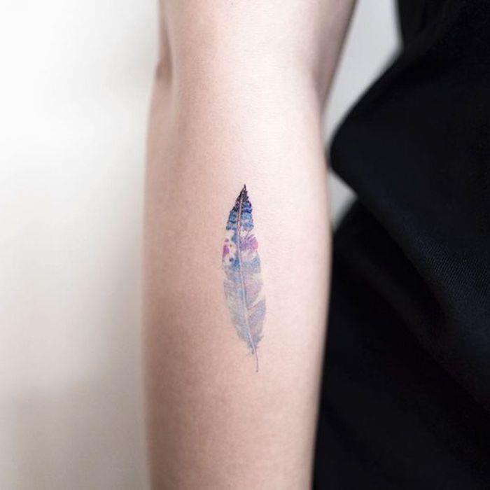 tetovaža lila in modrega perja, indijski simbol, minimalistična in barvita ženska tetovaža podlakti