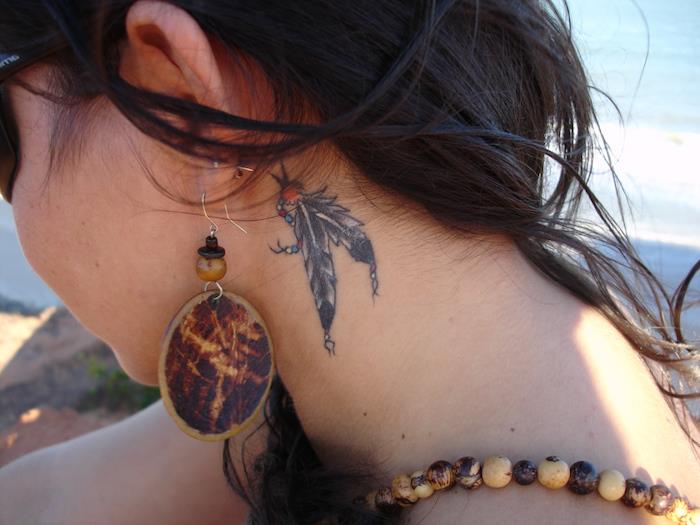 moters tatuiruotė, ilgi plaukai tamsiai rudos spalvos, mediniai auskarai
