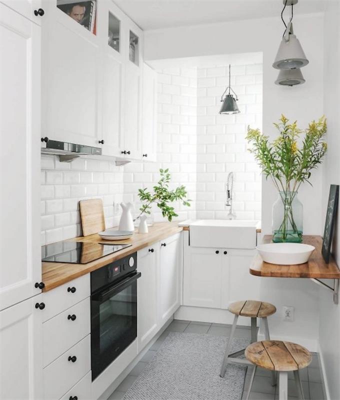 baltos virtuvės modelis su balta aukšta spintele ir žema spintele, mediniu stalviršiu, purslų dėže ir balta plytelių siena