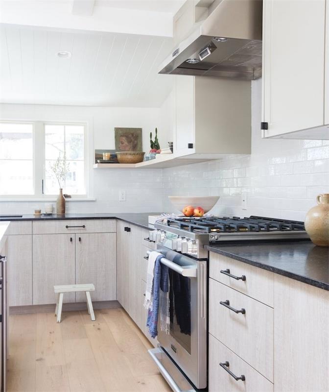 maža virtuvė su šviesios medienos pagrindo spintele ir juodu stalviršiu, balta spintelė, nerūdijančio plieno dulkių siurblys, šviesus parketas