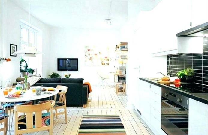 açık plan mutfak, oval yemek masası, büyük ahşap sandalyeler, siyah kanepe, beyaz boyalı ahşap zemin, küçük mutfak düzeni