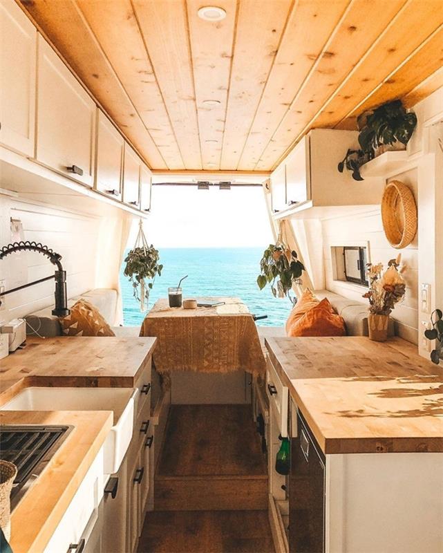 majhna vzporedna kuhinja iz belega lesa, visoko pohištvo, ki pokriva parket, ki sam spremeni kombi v avtodom