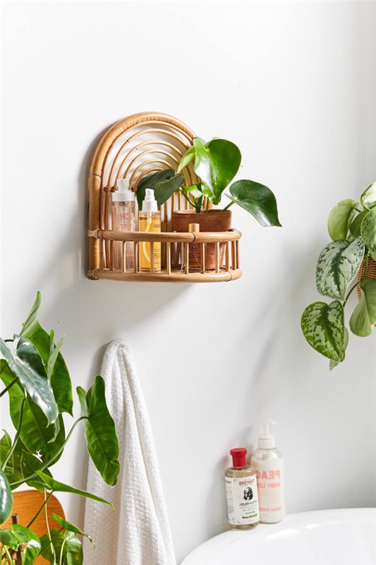 mažas egzotiško stiliaus vonios kambarys su augalais ir aksesuarais iš natūralaus pluošto, rotango pakabos formos lentynos modelis