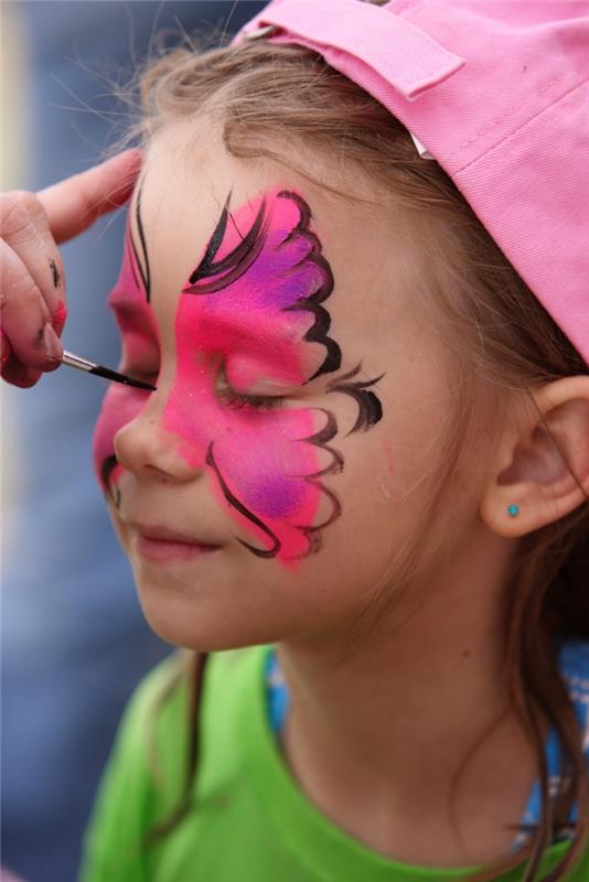 preprost model otroškega ličila z učinkom metulja z rožnatimi krili z vijoličnimi poudarki in črnimi obrisi obraza s svinčnikom