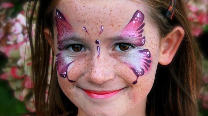 vijoličasti vzorec metulja na obrazu dekleta z barvo in šablono za otroški obraz, kostum za punce