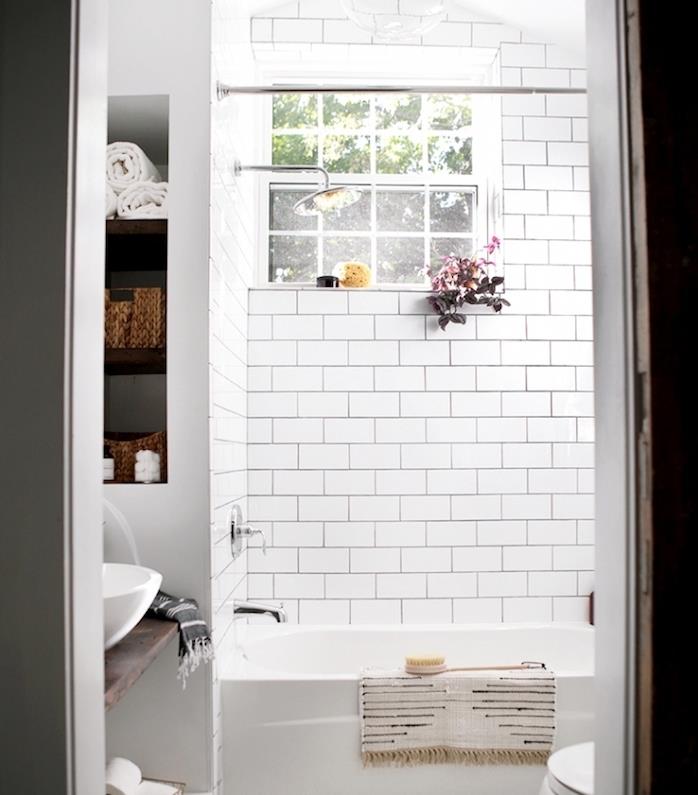 beyaz küvetli küçük banyo, beyaz metro döşemesi, depolu duvar nişi, rustik ahşap bir tahta üzerinde lavabo