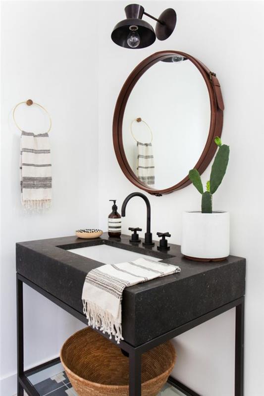 majhna sodobna kopalnica, majhna kopalniška dekoracija, okroglo ogledalo z rjavim okvirjem, črna lesena omara, črna industrijska svetilka nad ogledalom