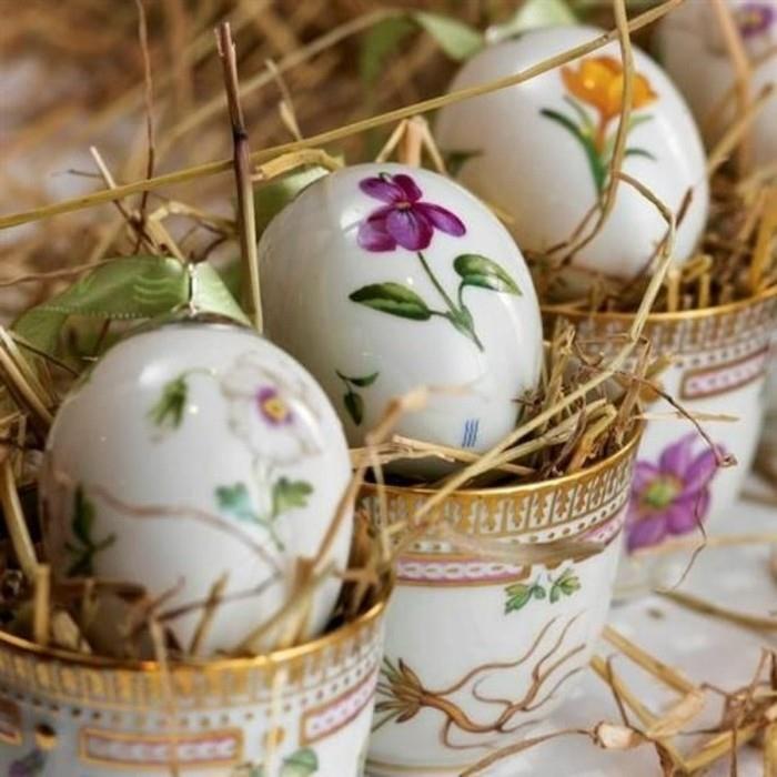 maži gražiai dekoruoti puodeliai, užpildyti šiaudais ir kiaušiniais, dekoruoti gėlių raštais