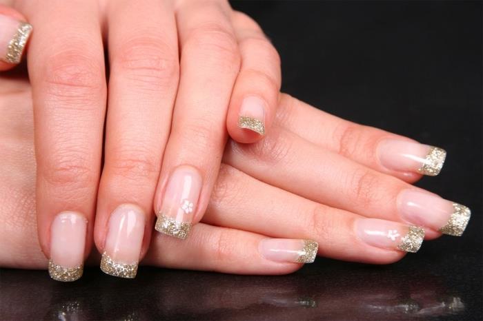 Ideja za dekoracijo gela za nohte v slogu francoske manikure s prozorno podlago in zlatimi bleščečimi nasveti, enostaven model nail art