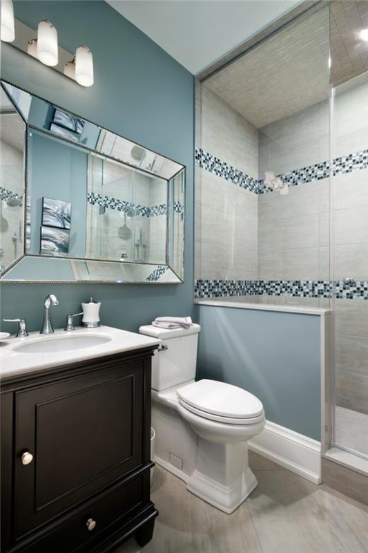 majhna kopalnica v pastelno modrih in belih barvah z belimi in modrimi mozaičnimi črtami v italijanskem tušu