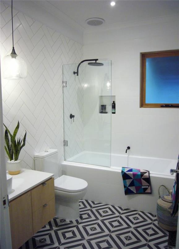 fotografija majhne kopalnice s črno -belimi keramičnimi tlemi z visečo omarico za umivalnik v bež barvi