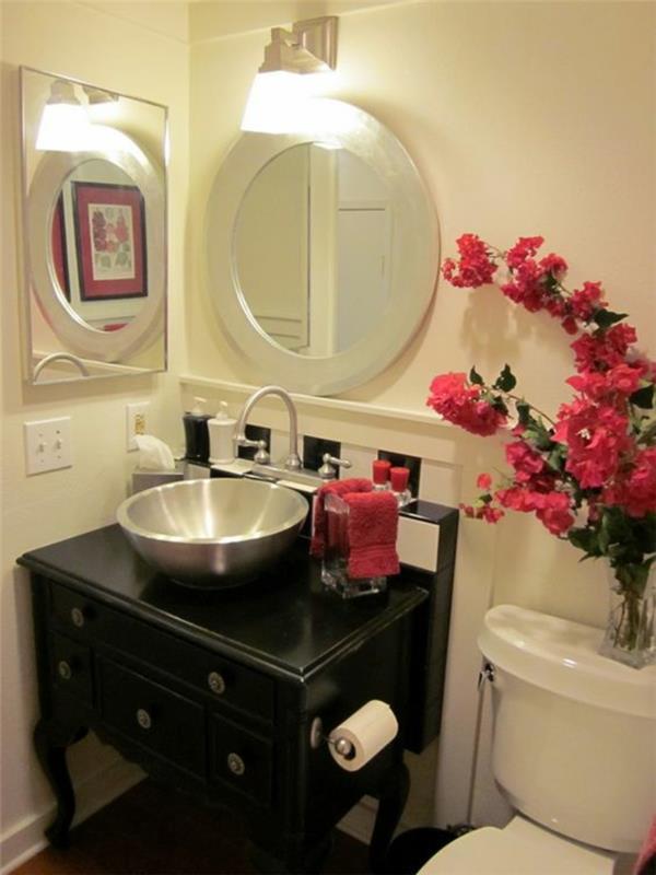 mažas vonios kambarys su dviem apvaliais ir kvadratiniais veidrodžiais, kad būtų daugiau šviesos