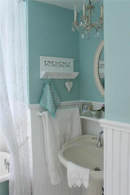 majhna kopalnica v nežno pastelno modri in otrcani elegantni beli barvi